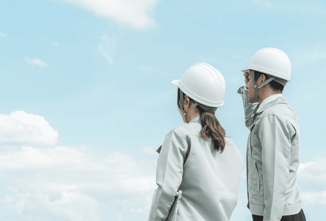 白いヘルメットを被った二人が空を見つめてる写真